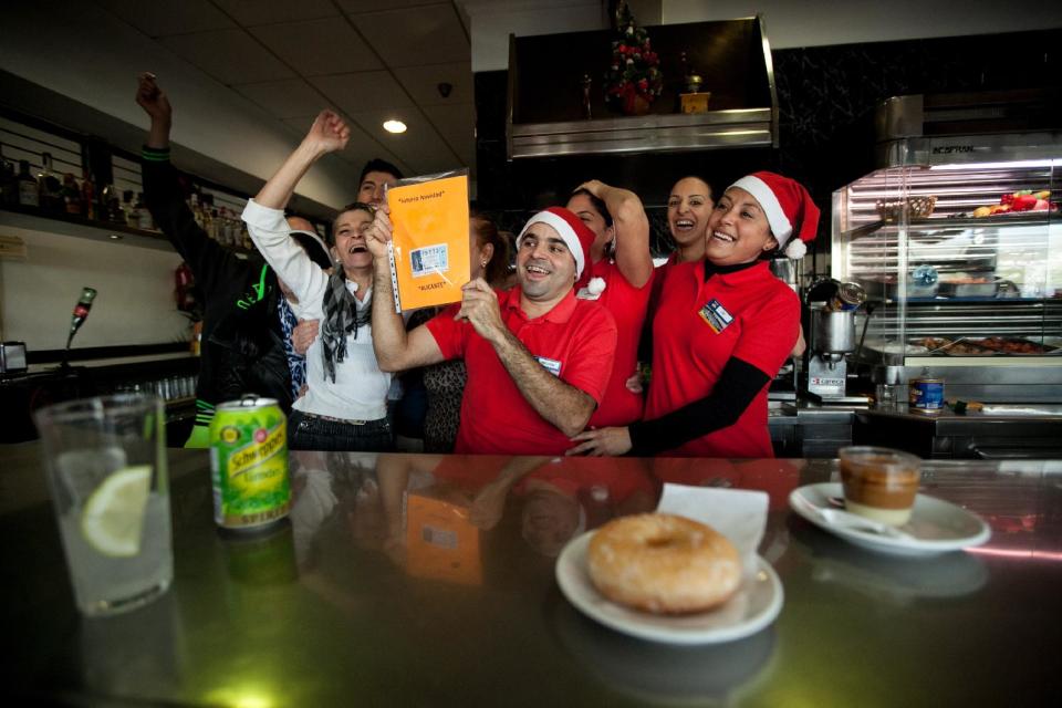 Gas station workers celebrate after winning the second prize of the Christmas lottery “El Gordo” (“The Fat One”) in Santa Cruz de Tenerife in the Canary Islands, Spain, Sunday Dec. 22, 2013. Millions of Spaniards are glued to televisions as the country's cherished Christmas lottery, the world's richest, distributes a bounty of 2.5 billion euros ($3.4 billion) in prize money to winning ticket owners. The draw is so popular that most of Spain's 46 million inhabitants traditionally watch some part of it live in the hope that the school children singing out winning numbers will call out their ticket. The top prize, known as "El Gordo" (The Fat One), gives lucky winners 400,000 euros per ticket Sunday, while the second-best number nets 125,000 euros. (AP Photo/Andres Gutierrez)