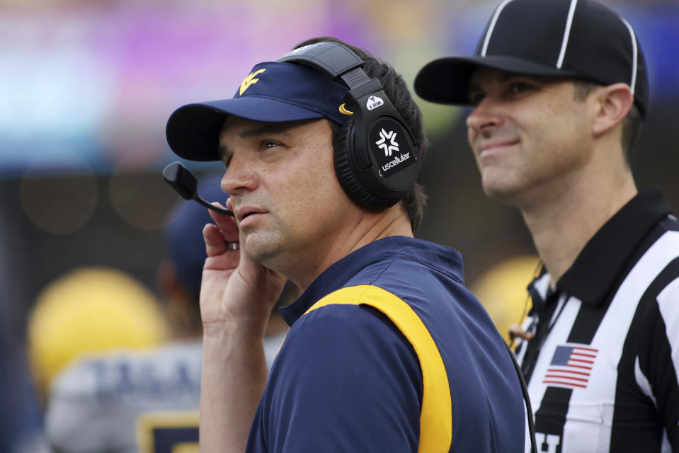 West Virginia head coach Neal Brown talks into his headset during the first half of an NCAA football game against Duquesne, Saturday, Sept. 9, 2023, in Morgantown, W.Va. (AP Photo/Chris Jackson)