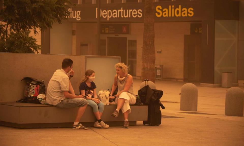 Passengers waiting outside Tenerife South airport after flights were cancelled due to a sandstorm on Sunday.