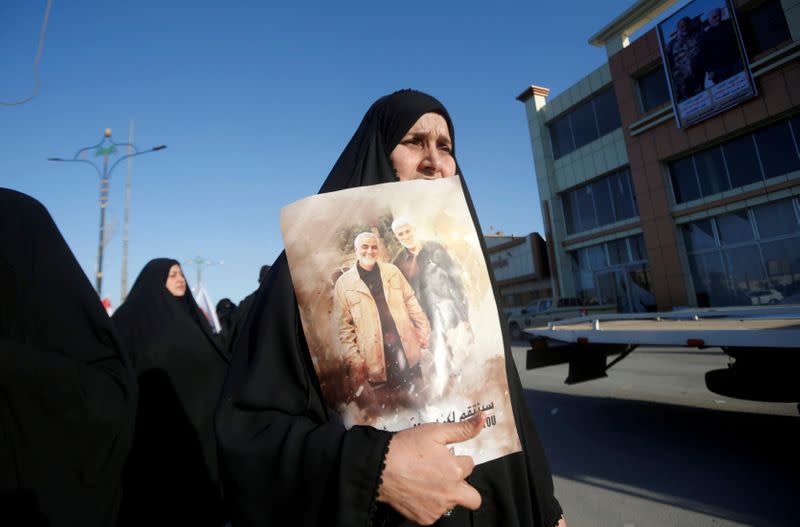 FOTO DE ARCHIVO: Una mujer iraquí sostiene una foto del General de División iraní Qassem Soleimani, jefe de la Fuerza de élite Quds, y del comandante de la milicia iraquí Abu Mahdi al-Muhandis, que murieron en un ataque aéreo en el aeropuerto de Bagdad, durante un cortejo fúnebre por el comandante de la milicia Abu Mahdi al-Muhandis, en Basora, Irak, el 7 de enero de 2020