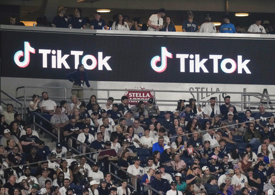 FILE - Fans sit under a TikTok ad at a baseball game at Yankee Stadium, April 14, 2023, in New York. A bill that could lead to the popular video-sharing app TikTok being unavailable in the United States is quickly gaining traction in the House. Lawmakers advanced legislation against TikTok Thursday as they voiced concerns about the potential for the platform to surveil and manipulate Americans. (AP Photo/Frank Franklin II, File)