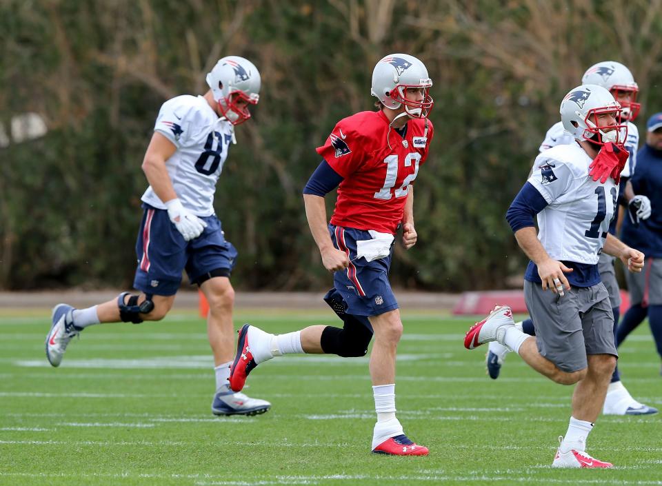 TEMPE, AZ - JANUARY 29:   Tom Brady #12 of the New England Patriots warms up with teammates Rob Gronkowski #87 and Julian Edelman #11 during the New England Patriots Super Bowl XLIX Practice on January 29, 2015 at the Arizona Cardinals Practice Facility in Tempe, Arizona.  (Photo by Elsa/Getty Images)