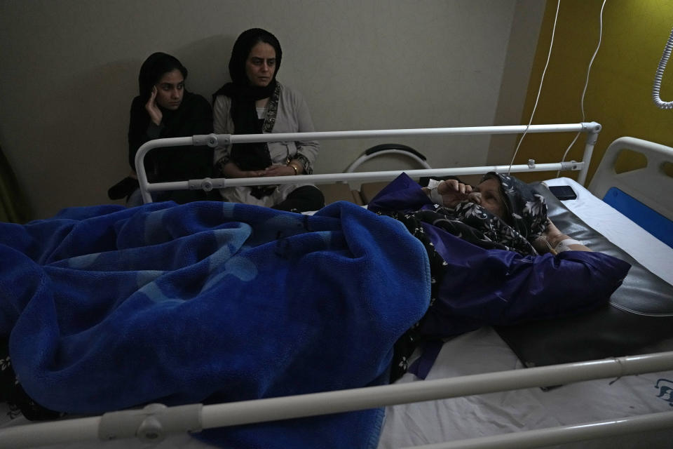Fatemeh Rostami who was wounded in Wednesday's bomb explosion lies on bed as her daughters sit next to her at Bahonar hospital in the city of Kerman about 510 miles (820 kms) southeast of the capital Tehran, Iran, Thursday, Jan. 4, 2024. Investigators believe suicide bombers likely carried out an attack on a commemoration for an Iranian general slain in a 2020 U.S. drone strike, state media reported Thursday, as Iran grappled with its worst mass-casualty attack in decades and as the wider Mideast remains on edge. (AP Photo/Vahid Salemi)