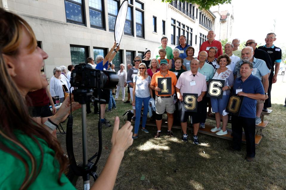 Jenny Thebault, a science teacher at Gesu School, works at getting former students from 1960 to 1964 to pose for a class picture, during the 100-year celebration at Gesu Catholic Church and School in Detroit on Saturday, July 30, 2022.