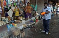 A municipal worker disinfects a pavement in a market area during a 21-day nationwide lockdown to limit the spreading of the coronavirus disease (COVID-19), in Kolkata