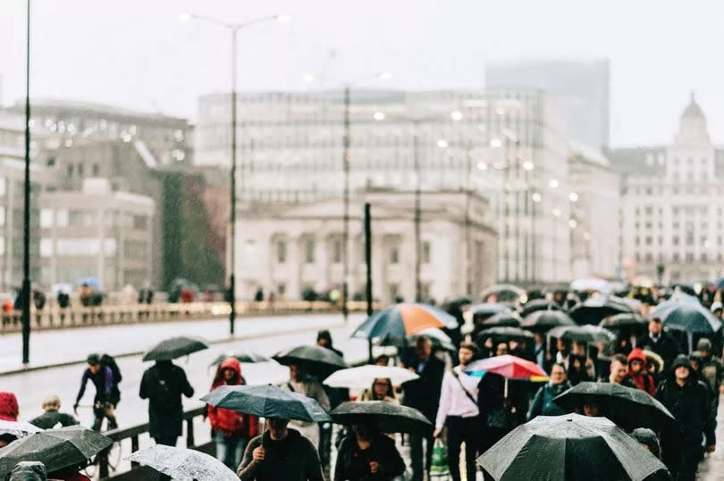 People on London Bridge with umbrellas - UK