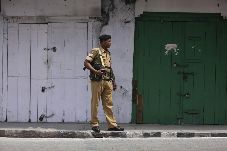 An Indian paramilitary soldier stands guard near closed shops in Jammu, India, Tuesday, Aug.6, 2019. India's lower house of Parliament was set to ratify a bill Tuesday that would downgrade the governance of India-administered, Muslim-majority Kashmir amid an indefinite security lockdown in the disputed Himalayan region. The Hindu nationalist-led government of Prime Minister Narendra Modi moved the "Jammu and Kashmir Reorganization Bill" for a vote by the Lok Sahba a day after the measure was introduced alongside a presidential order dissolving a constitutional provision that gave Kashmiris exclusive, hereditary rights. (AP Photo/Channi Anand)