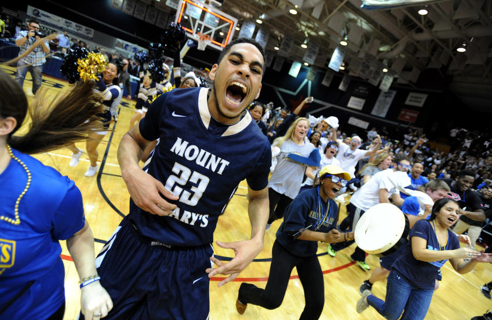 Mount St. Mary's Julian Norfleet (23) celebrates as fans rush the court following a win over Robert Morris during Northeastern Conference championship NCAA college basketball game on Tuesday, March 11, 2014, in Coraopolis, PA. Mt. Saint Mary won 88-71.(AP Photo/Don Wright)