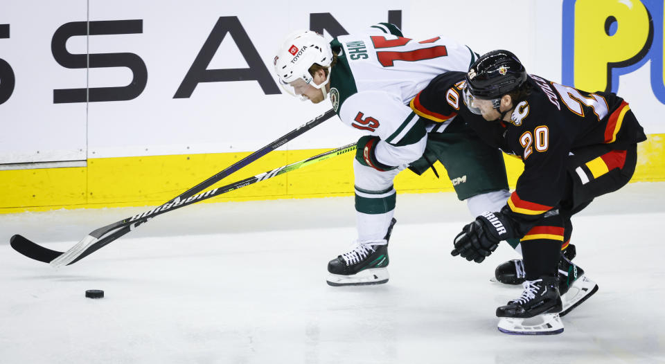 Minnesota Wild forward Mason Shaw, left, is checked by Calgary Flames forward Blake Coleman during the second period of an NHL hockey game Saturday, March 4, 2023, in Calgary, Alberta. (Jeff McIntosh/The Canadian Press via AP)
