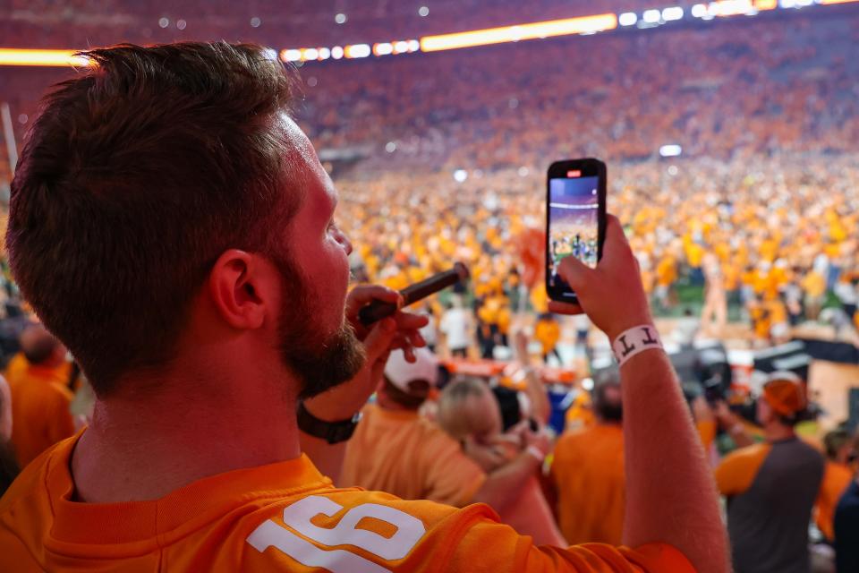 Oct 15, 2022; Knoxville, Tennessee, USA; A Tennessee Volunteers fan watches on his phone as fans tear down the goal posts after beating the Alabama Crimson Tide at Neyland Stadium.