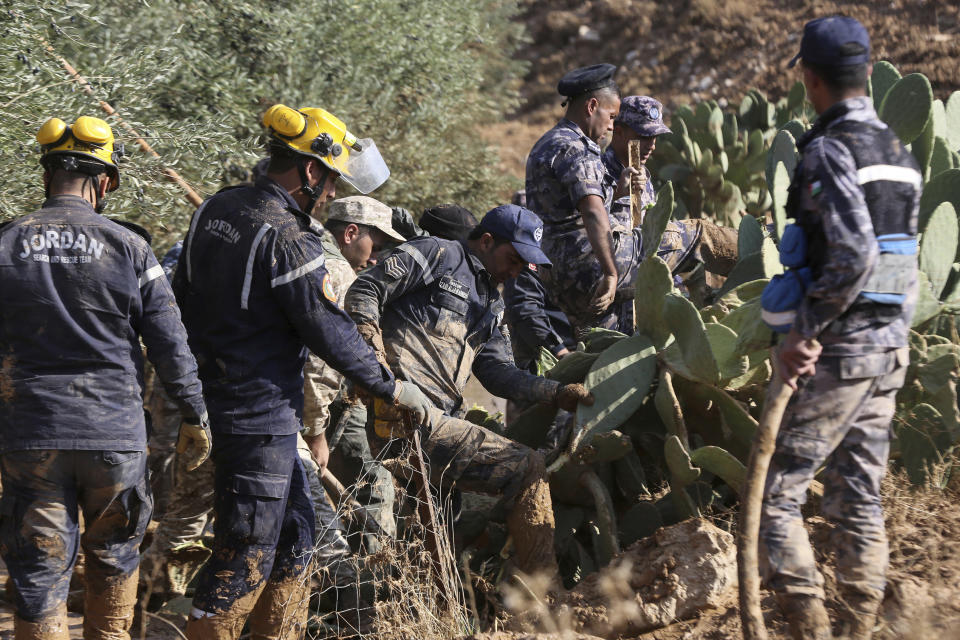 Jordanian rescue teams search Saturday, Nov. 10, 2018 for missing people in the Madaba area, south of the capital of Amman, after flash floods unleashed by heavy rain a day earlier killed several people. (AP Photo/Raad Adayleh)