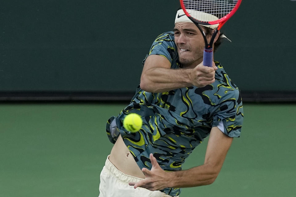 Taylor Fritz returns to Jannik Sinner, of Italy, at the BNP Paribas Open tennis tournament Thursday, March 16, 2023, in Indian Wells, Calif. (AP Photo/Mark J. Terrill)