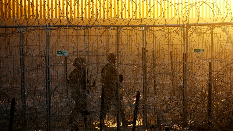 Members of the Texas National Guard stand guard near a razor wire fence to inhibit the crossing of migrants into the United States, seen from Ciudad Juarez, Mexico, June 4, 2024. REUTERS/Jose Luis Gonzalez - Jose Luis Gonzalez/Reuters
