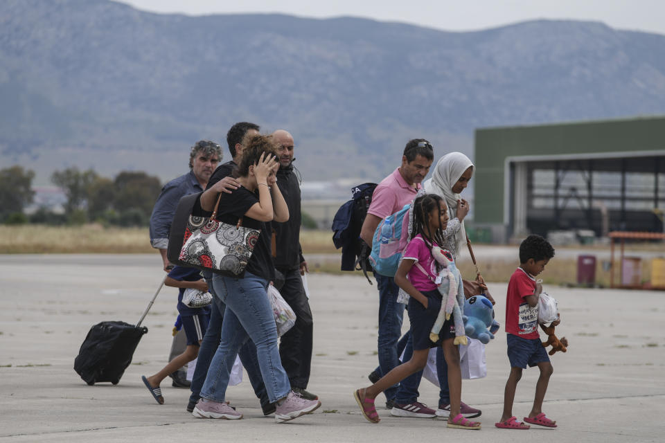 Passengers from Sudan react after disembarking from a military plane at Elefsina Air Force Base, in western Athens, Greece, on Tuesday, April 25, 2023. As continued fighting raises fears that Sudan could plunge deeper into chaos, foreign governments are scrambling to get their diplomats and other citizens safely out. (AP Photo/Petros Giannakouris)