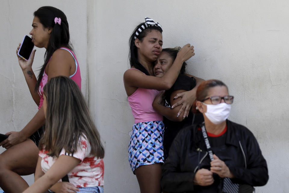 People wait outside the Getulio Vargas Hospital for the arrival of people who were injured or killed during a police raid in the Vila Cruziero favela of Rio de Janeiro, Brazil, Tuesday, May 24, 2022. Police in Rio de Janeiro raided the Vila Cruzeiro favela before dawn Tuesday in an operation that prompted a fierce firefight and state officials said at least 10 people died. (AP Photo/Bruna Prado)