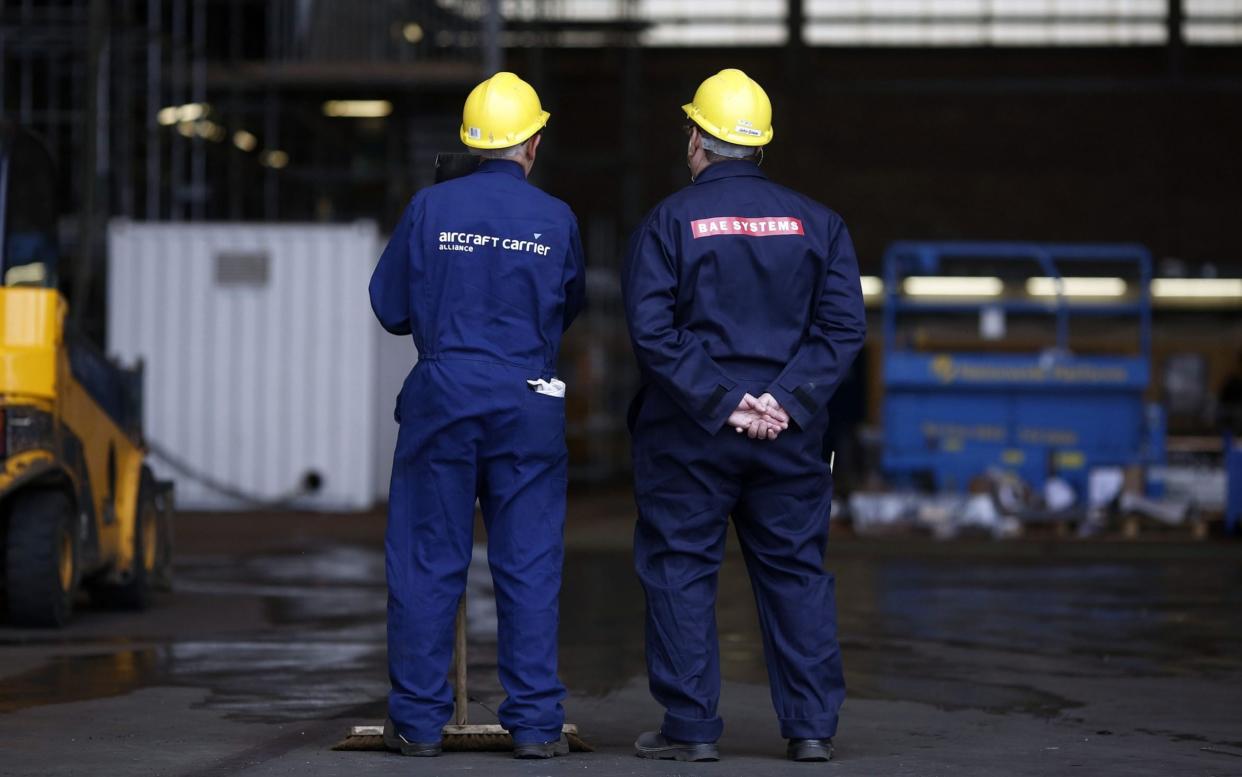 Employees take a break from working on the British Royal Navy's new HMS Prince of Wales aircraft carrier - © 2014 Bloomberg Finance LP.