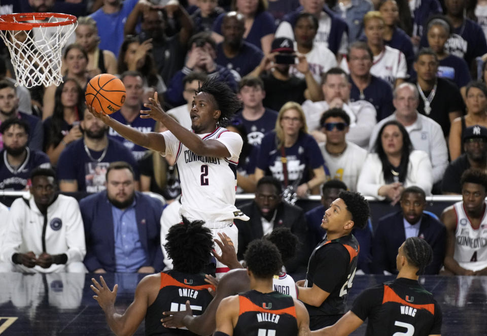 Connecticut guard Tristen Newton (2) drives to the basket over Miami defenders during the second half of a Final Four college basketball game in the NCAA Tournament on Saturday, April 1, 2023, in Houston. (AP Photo/Godofredo A. Vasquez)