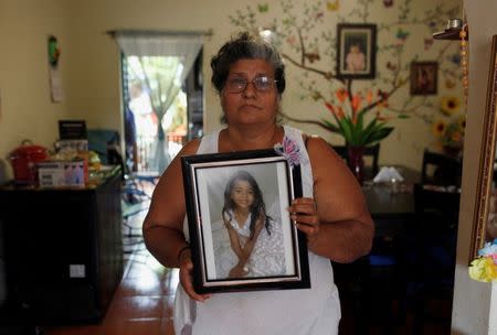 Ana Henriquez poses for a picture while holding a photograph of her granddaughter Alison Valencia, who was detained along with her mother and then separated when they arrived in the U.S., in Armenia, El Salvador June 20, 2018. REUTERS/Jose Cabezas