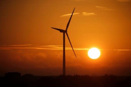FILE PHOTO: A power-generating windmill turbine is pictured during sunrise at a wind park in Escarmain near Cambrai, France, August 9, 2017. REUTERS/Pascal Rossignol