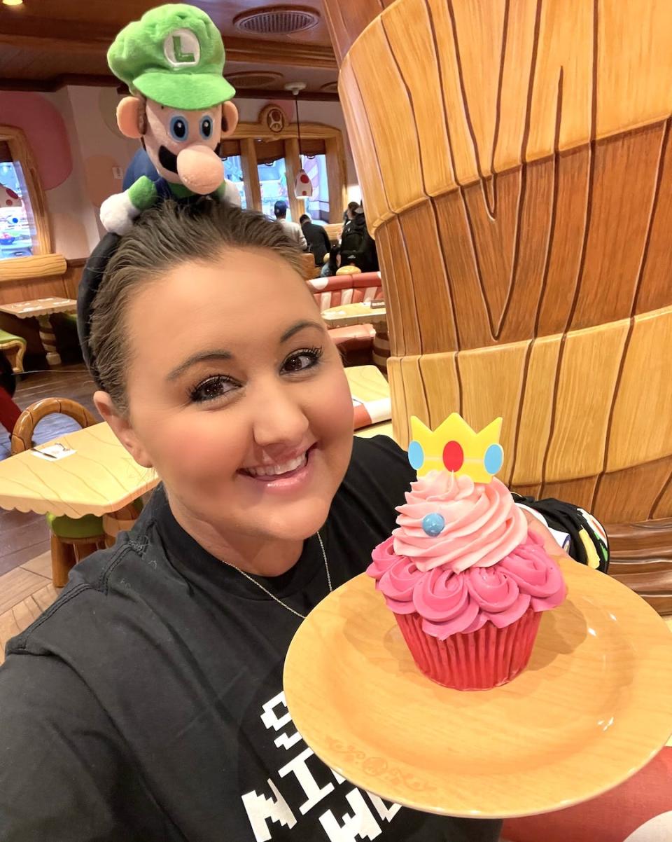 carly caramanna holding a princess peach cupcake