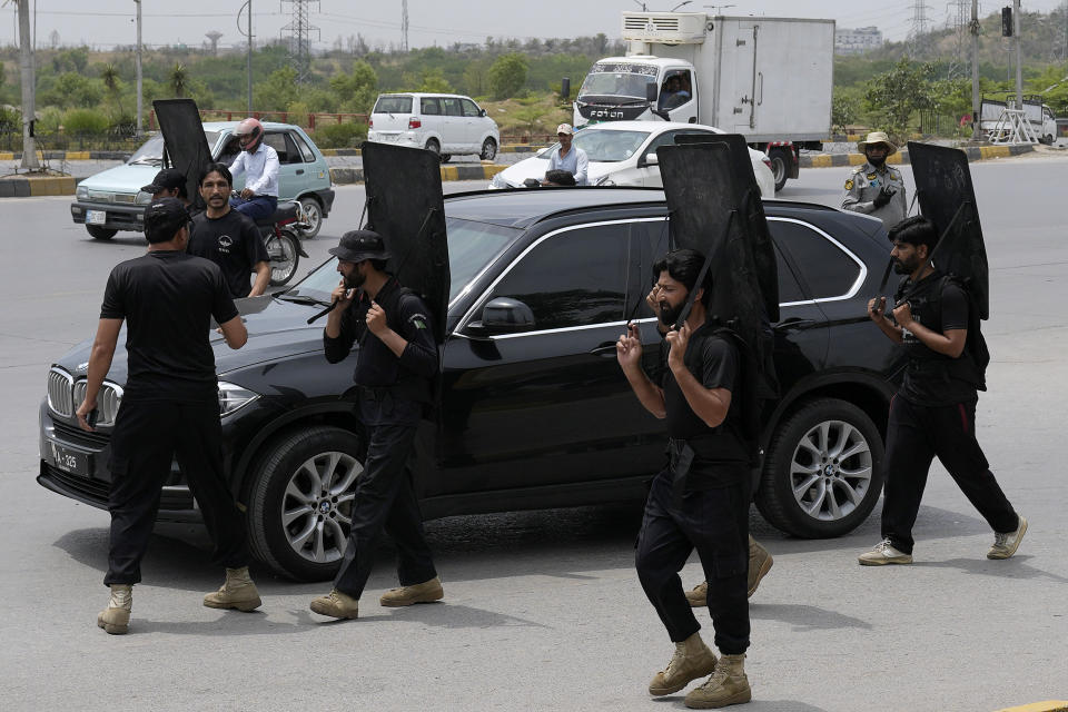 Security personnel secure a vehicle carrying the Pakistan's former Prime Minister Imran Khan leaves after his court appearance, in Islamabad, Pakistan, Tuesday, May 23, 2023. Khan on Tuesday pressed his legal battle before a court in the capital, Islamabad, which granted him protection from arrest until early next month in several cases where he faces terrorism charges for inciting violence. (AP Photo/Anjum Naveed)