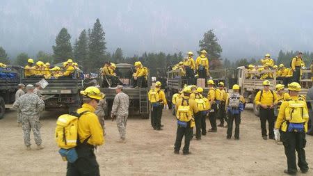 Washington State National Guard ground fire fighting personnel arrive to support efforts to contain the Carlton Complex wildfire burning in North Central Washington, near Wenatchee, in this handout picture released by the Washington State National Guard July 22, 2014. REUTERS/Washington State National Guard/Handout via Reuters