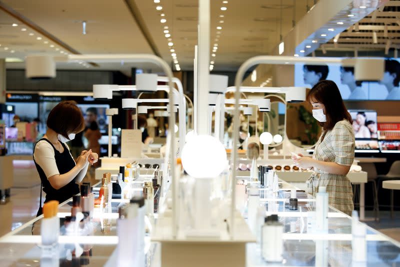 Women wearing masks to avoid the spread of the coronavirus disease (COVID-19) shop at a cosmetic shop in a department store in Seoul