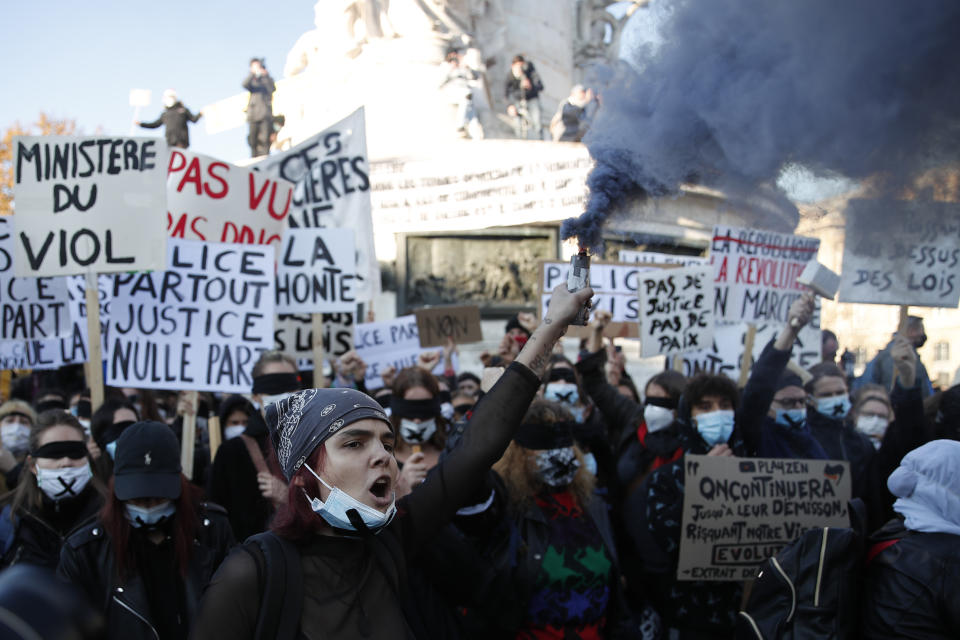 A protester holds a flare during a demonstration security law that would restrict sharing images of police, Saturday, Nov. 28, 2020 in Paris. Critics of a proposed French security law in France that would restrict sharing images of police are gathering across the country in protest. Civil liberties groups and journalists are concerned that the measure will stymie press freedoms and allow police brutality to go undiscovered and unpunished. (AP Photo/Francois Mori)