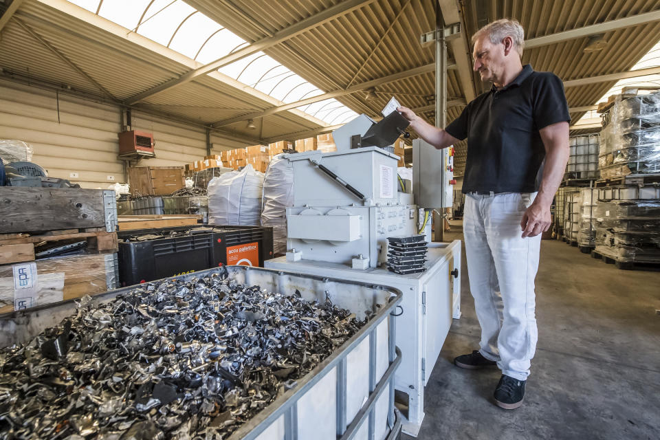 In this photo taken on July 13, 2018, a worker shreds electronic elements at the Out Of Use company warehouse in Beringen, Belgium. Out Of Use dismantles computer, office and other equipment and recuperates an average of around 90 percent of the raw materials from electronic waste. (AP Photo/Geert Vanden Wijngaert)