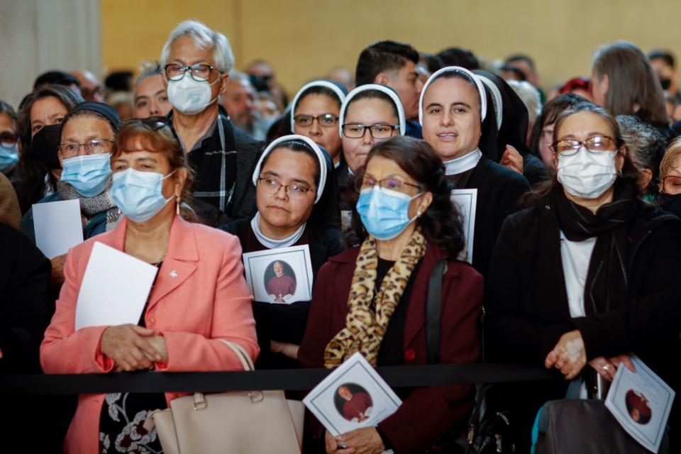 Mourners watch as Archbishop Jose H. Gomez leads the funeral procession