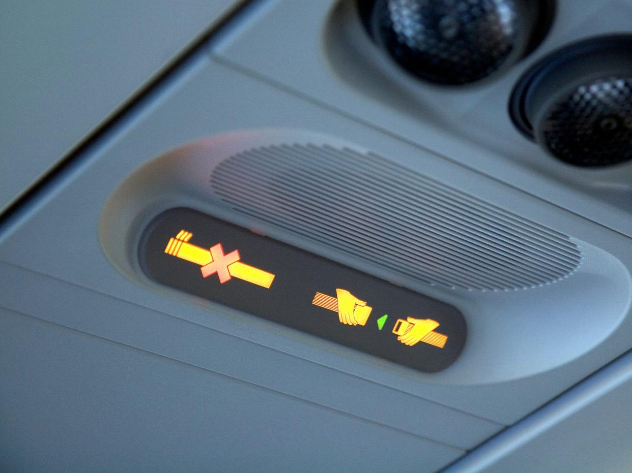 A "no smoking" and "fasten seatbelt" sign on a commercial aircraft.