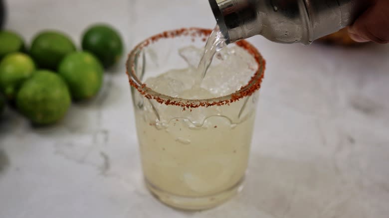 pouring margarita into glass