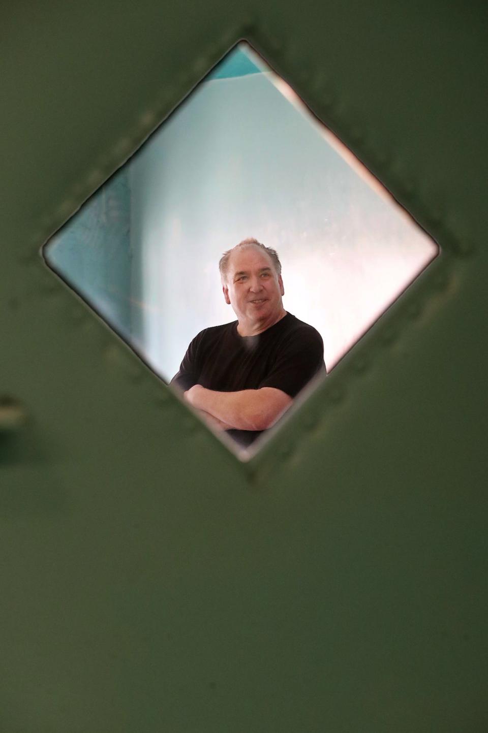 Scott Summers, co-owner of the Linda Theater, is framed in the window of one of the doors as he talks about the renovations that are planned for the Goodyear Heights neighborhood movie house in Akron.