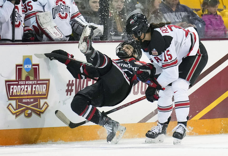 Northeastern forward Mia Brown, left, falls along the boards after colliding with Ohio State forward Gabby Rosenthal, right, in the third period of a national semifinal in the women's NCAA Frozen Four college hockey tournament in Duluth, Minn., Friday, March 17, 2023. (Shari L. Gross/Star Tribune via AP)