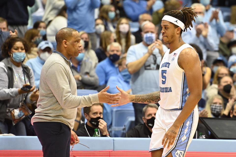 North Carolina coach Hubert Davis greets forward Armando Bacot as the Smith Center crowd applauds while Bacot checks out of Saturday night’s game against Georgia Tech for the final time.