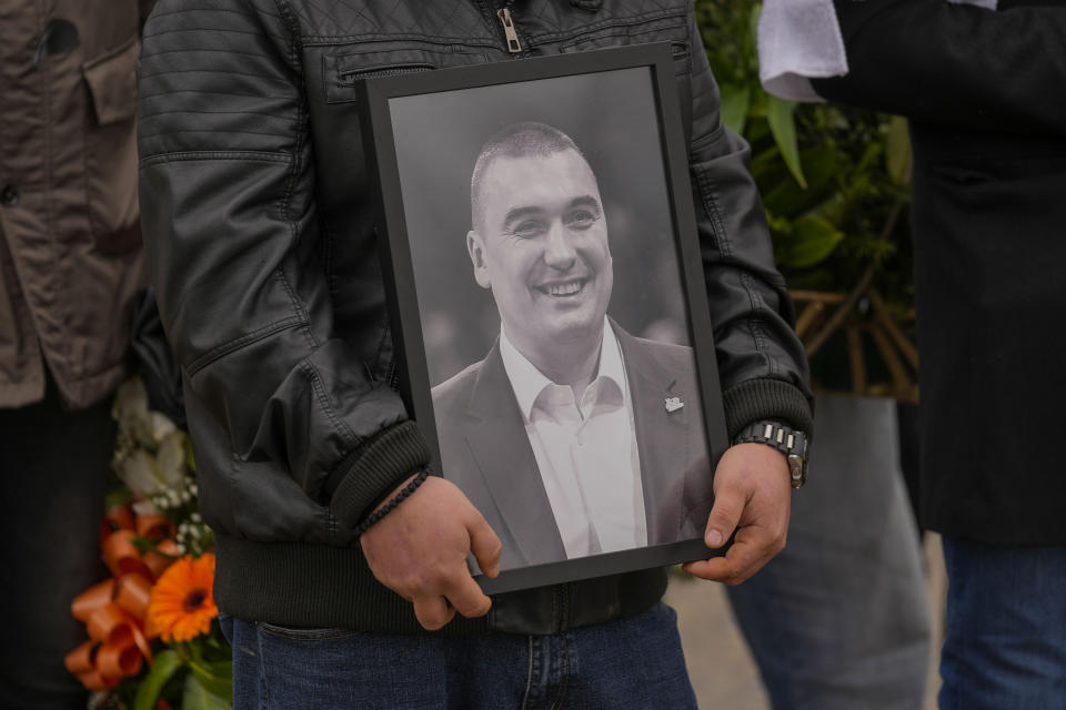 A man holds a photo of Golden State Warriors assistant coach Dejan Milojevic during his funeral in Belgrade, Serbia, Monday, Feb. 12, 2024. Milojevic, 46, died on Jan. 17, in Salt Lake City after heart attack. (AP Photo/Darko Vojinovic)