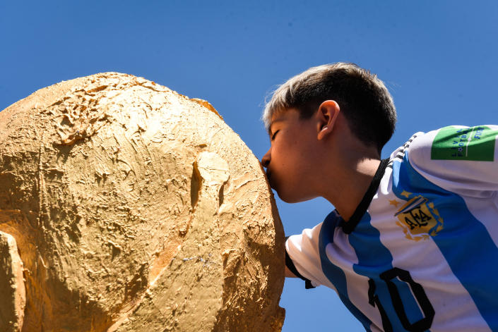 Soccer Football - FIFA World Cup Final Qatar 2022 - Fans in Buenos Aires watch Argentina v France - Buenos Aires, Argentina - December 18, 2022 An Argentina fan kisses a replica trophy in Buenos Aires watch the match between Argentina v France REUTERS/Mariana Nedelcu