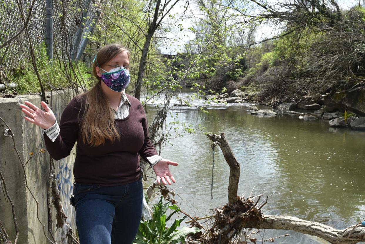 Jennifer Kunze, Maryland manager for nonprofit Clean Water Action, stands along the Jones Falls in Baltimore on April 13, 2021. Nearby, a pipe releases raw sewage into the waterway during heavy rains. Baltimore has struggled for decades with its leaky sewage system, and the cost of repairs has led to water affordability problems in the city.