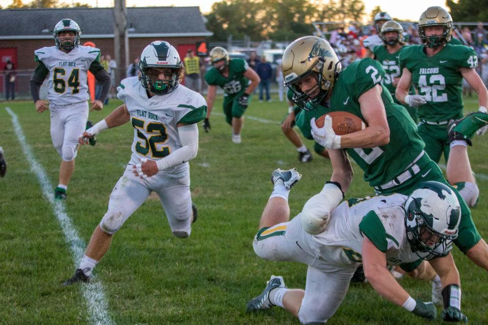 Michael Laboe of St. Mary Catholic Central is tripped up by Flat Rock's Joey Godfroy (20) as Andrew Given (52) comes to assist during a 20-14 SMCC win Friday night.