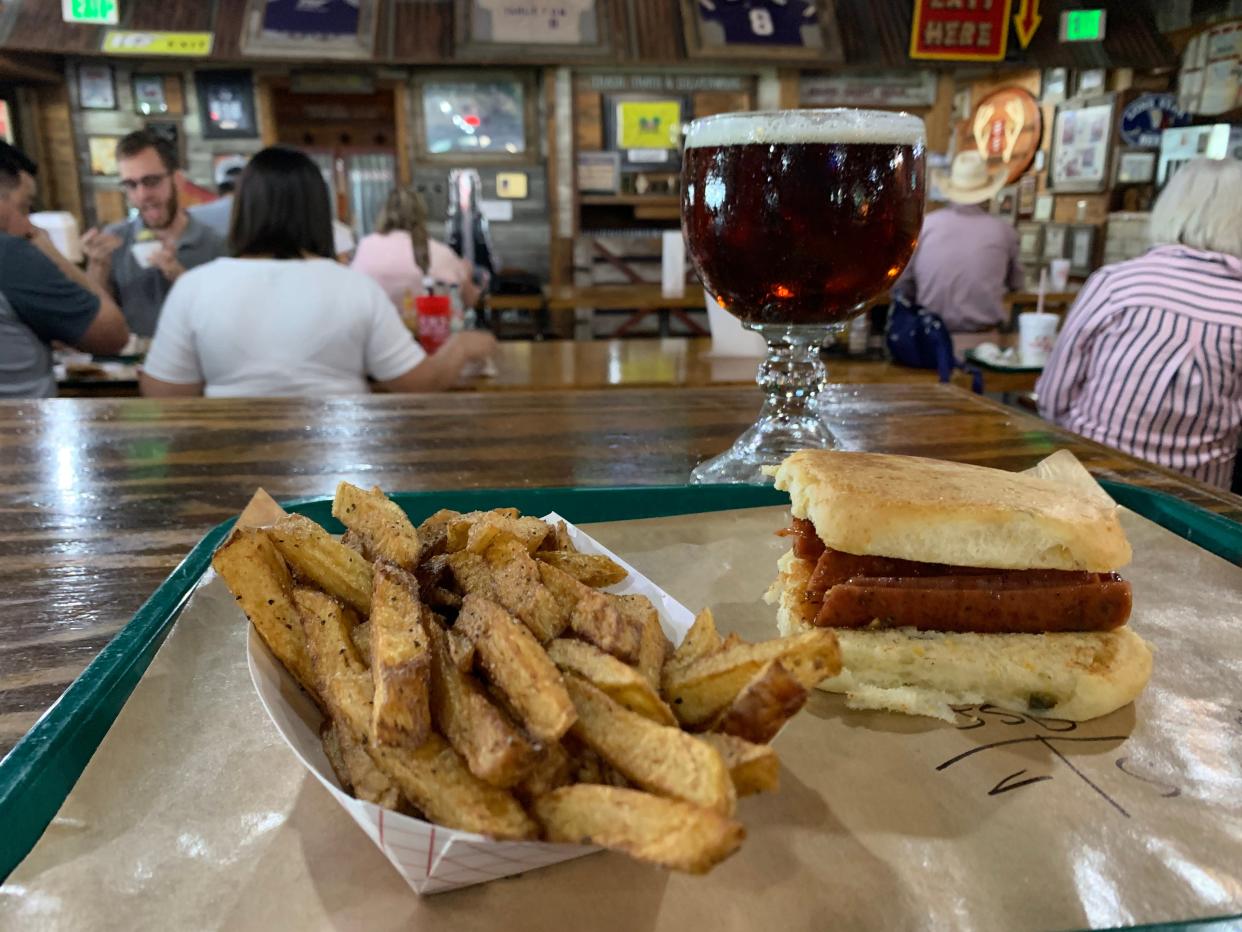 The real deal: Spicy sausage sandwich with fries and Shiner Bock at Hard Eight Barbecue in Stephenville.