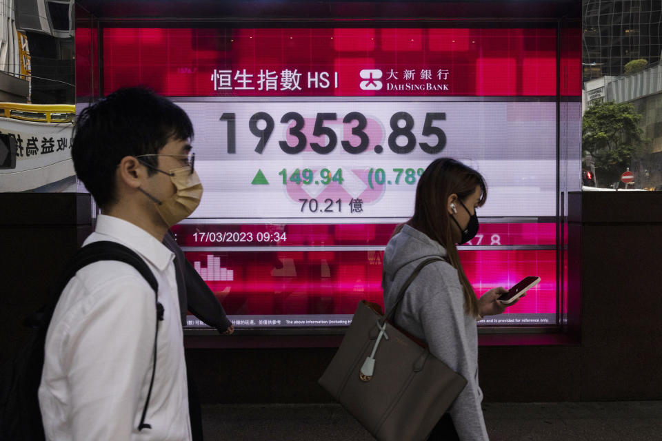 Pedestrians pass the Dah Sing Bank's electronic screen in Hong Kong on Friday, March 17, 2023. Shares advanced Friday in Asia, tracking a rally on Wall Street after a group of big banks offered a lifeline to First Republic Bank, the lender investors had focused on in their latest hunt for troubles in the banking industry. (AP Photo/Louise Delmotte)