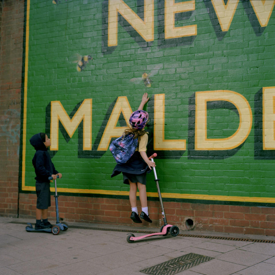 Two children play in front of a mural outside New Malden train station.<span class="copyright">Michael Vince Kim for TIME</span>