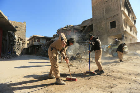 Workers clean the street in Mosul, Iraq, January 10, 2018. REUTERS/Ari Jalal/Files