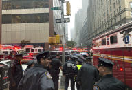 New York police officers monitor the streets near 51st Street and 7th Avenue, Monday, June 10, 2019, in New York, where a helicopter was reported to have crash landed on top of a building in midtown Manhattan. (AP Photo/Mark Lennihan)