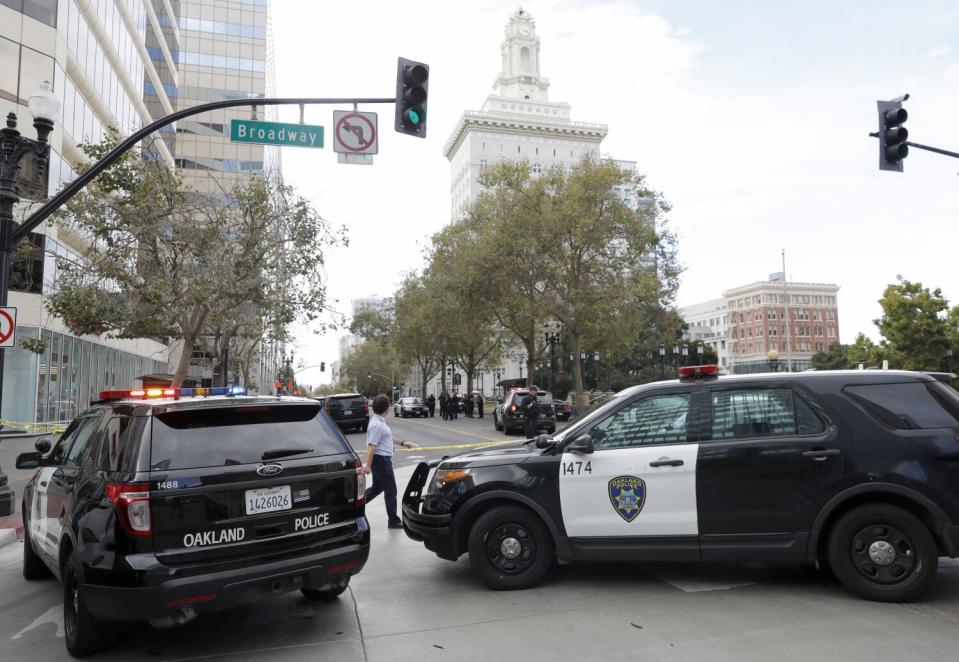 Police SUVs at an intersection blocked by yellow crime scene tape