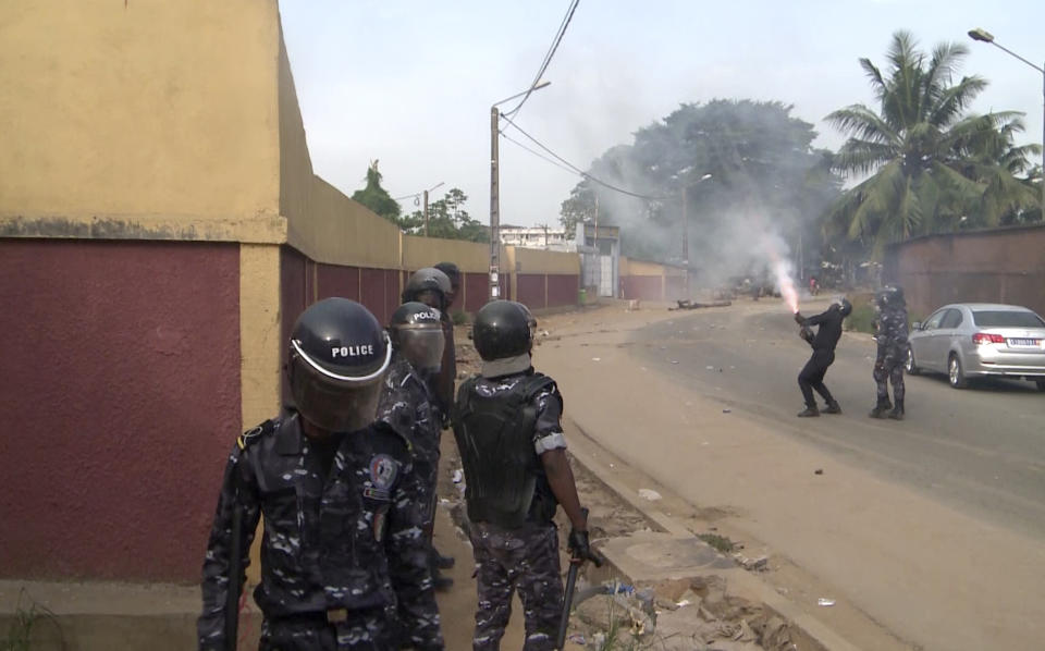 In this image made from video, security forces fire tear gas after a group of local residents demonstrated outside a coronavirus medical reception facility that was under construction in the Yopougon area of the commercial capital Abidjan, Ivory Coast, Monday, April 6, 2020. The protesters hampered the government's effort to build the emergency coronavirus medical reception facility in the crowded Yopougon area, ransacking the site and destroying equipment to be used to construct the center, saying they are worried that the triage center could expose their community to COVID-19. (AP Photo)