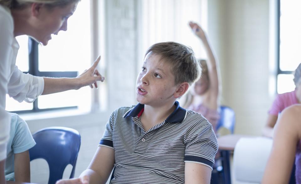 Adult scolding a child in a classroom