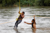 <p>A Honduran migrant, part of a caravan trying to reach the U.S., climbs down from the bridge that connects Mexico and Guatemala to avoid the border checkpoint in Ciudad Hidalgo, Mexico, Oct. 19, 2018. (Photo: Edgard Garrido/Reuters) </p>