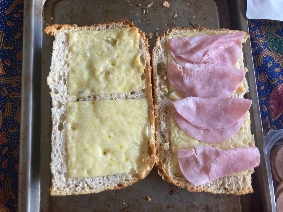 A picture of bread with layers of ham on it.