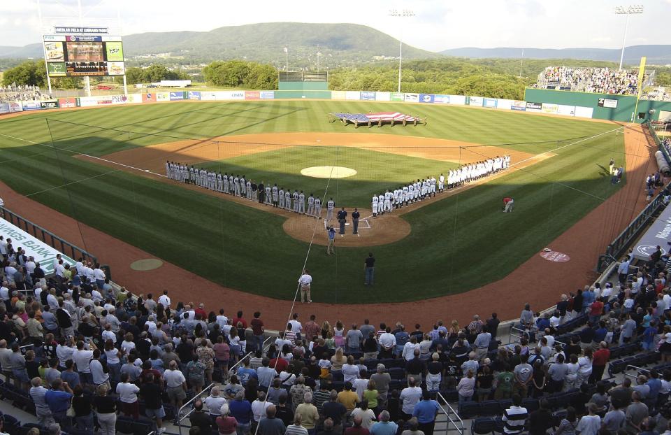FILE - In this June 20, 2006, file photo, teams line up along the baselines during the playing of the national anthem before the first game, in the inaugural season, of the State College Spike baseball team in State College, Pa. Major League Baseball is creating a minor league for top eligible prospects leading to the summer draft., the league announced Monday, Nov. 30, 2020. The founding members of the MLB Draft League are located in Ohio, Pennsylvania, West Virginia and New Jersey: the Mahoning Valley Scrappers, the State College Spikes, the Trenton Thunder, the West Virginia Black Bears and the Williamsport Crosscutters. (AP Photo/Pat Little, File)